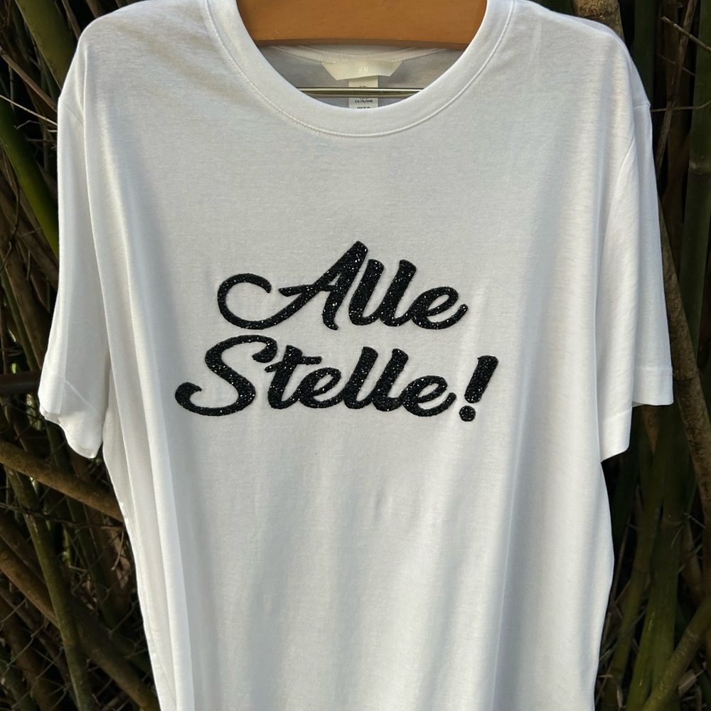 H&M Alle Stelle Sky High White Graphic Tee with Black Text